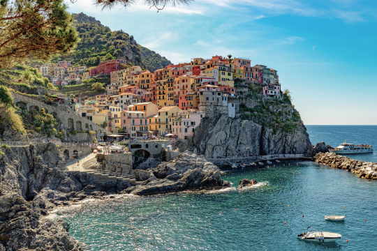 Blick auf ein kleines Dorf auf einem Felsen gelegen mit bunten kleinen H&auml;usern, rechts das Meer